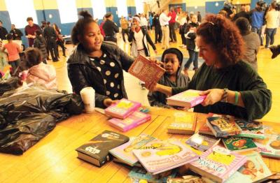 Susan Menino Fenton, right, handed out gifts to youngsters at the St. Peter&amp;#039;s Teen Center on Christmas Eve. Caleb Nelson photo